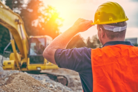 Man in Hard Hat at a Busy Construction Site