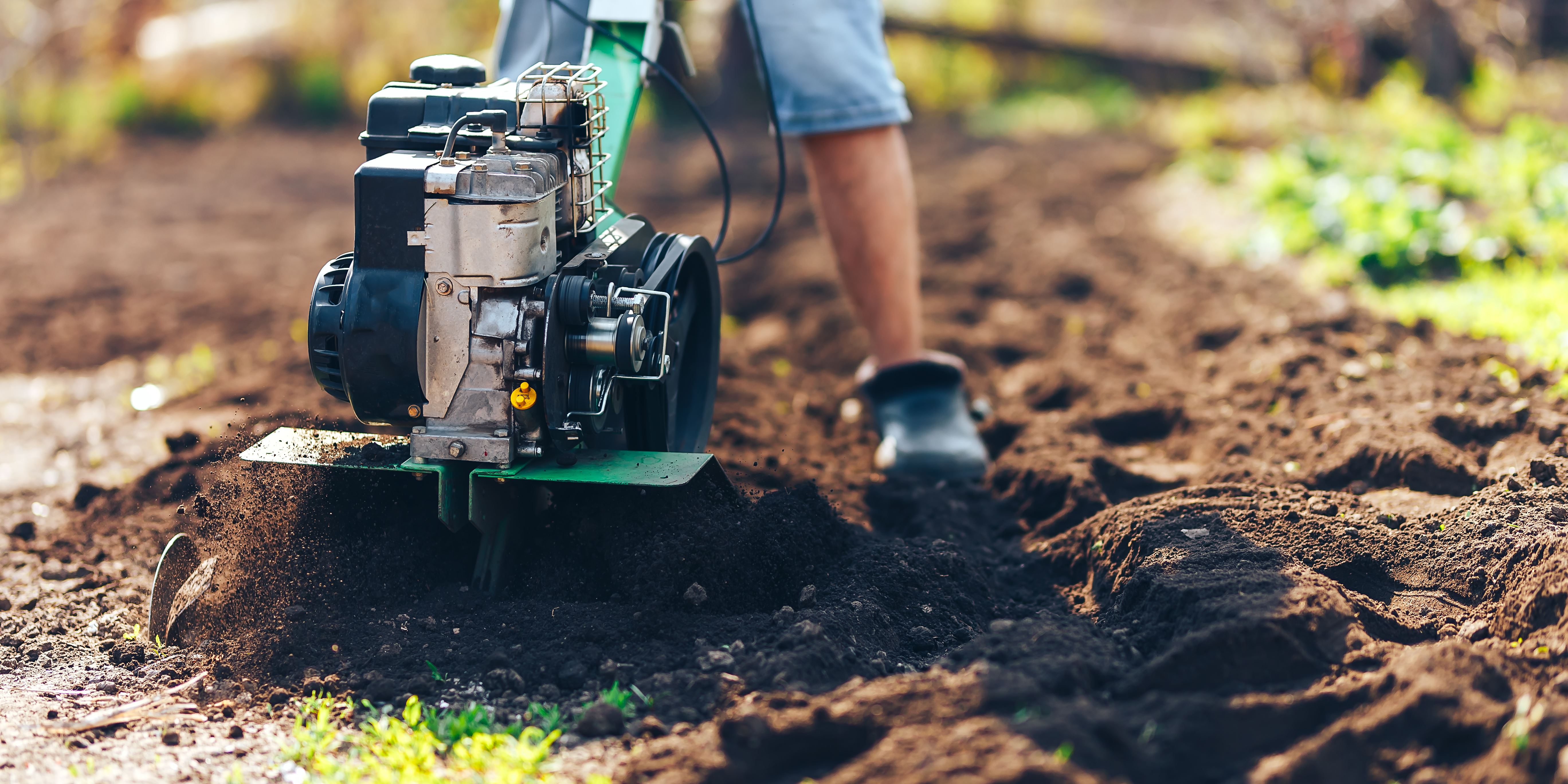 Image of Roto tiller in a garden turning soil